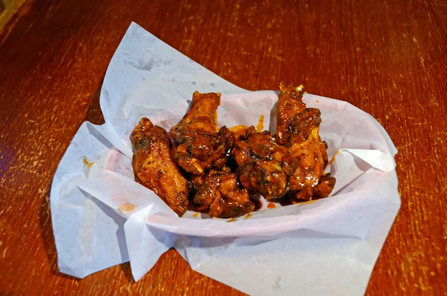 Basket of BBQ wings on deli paper at Grand Crossing Bar & Grill