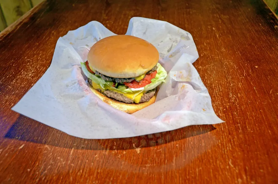 A cheeseburger on deli paper at Grand Crossing Bar & Grill