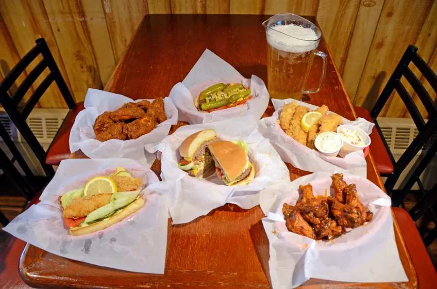A spread of wings, a cheeseburger, a perch po'boy, egg rolls and a glass of beer at Grand Crossing