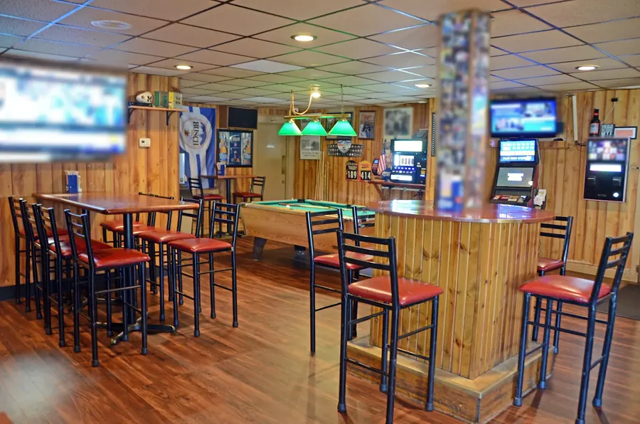 High-top tables and TVs at Grand Crossing, with the pool table and green lamps at the back