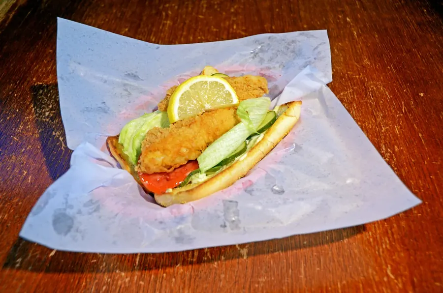 Fried Yellow Lake perch po'boy with lettuce, tomato and lemon on deli paper